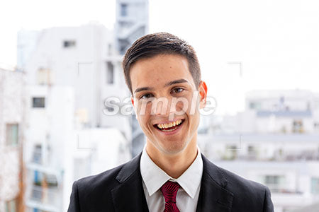 オフィス街で男性が正面を見て笑う a0010032PH