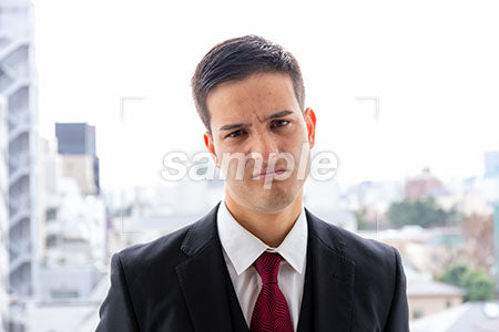 不満な表情で正面を見るジビネスマンの男性 a0010079PH