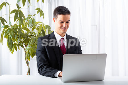 仕事をしながらパソコンを見て微笑む男 a0010165PH