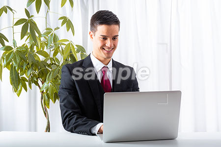 ビジネスマンの男性の笑顔の表情　パソコンを見て微笑む a0010166PH