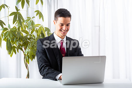 仕事をしながら男性がパソコンを見て笑う a0010172PH