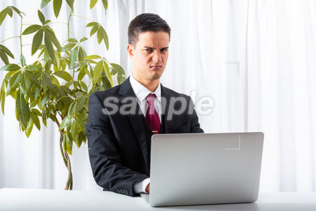 パソコンしながらビジネスマンの男性の怒る表情 a0010179PH