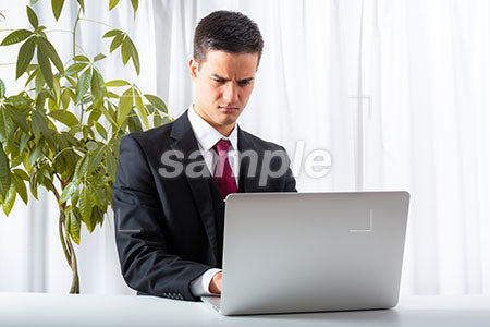パソコンでメールを打ちながら怒っているビジネスマン a0010187PH