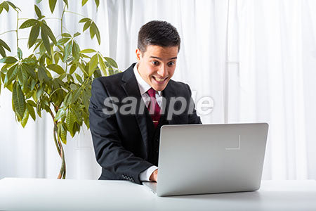 スーツを着ている外国人男性のパソコンを見て驚く a0010225PH