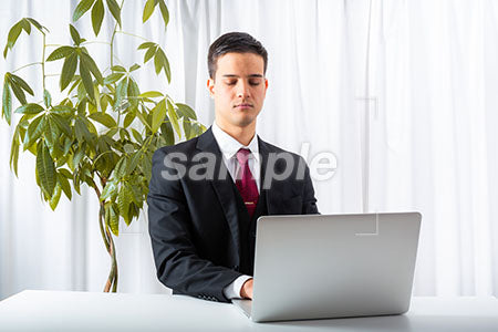 男性が疲れてパソコンの前で目を閉じる a0010239PH