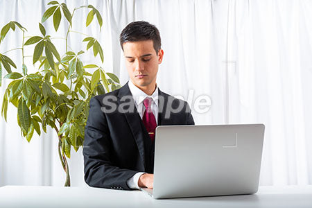 海外のビジネスマンがパソコンの前で目を閉じる a0010245PH