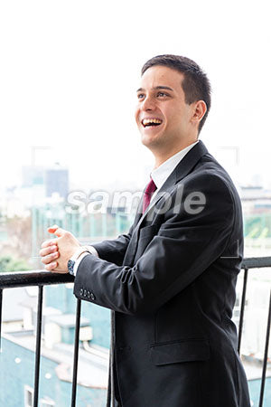 オフィスのベランダで男性の左上を見て笑う a0010268PH