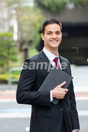 オフィス街で男性が正面を見て微笑む a0010358PH