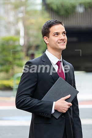 街中でビジネスマンの男性が微笑む a0010364PH