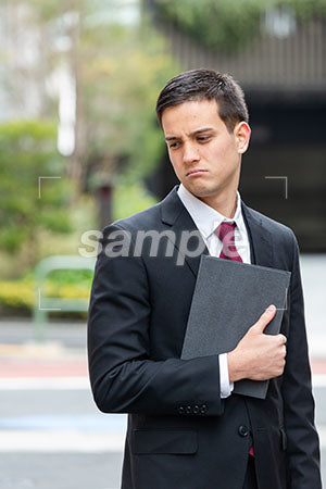 ビジネスマンの男性の悲しい表情 左下を見て悲しむ a0010394PH