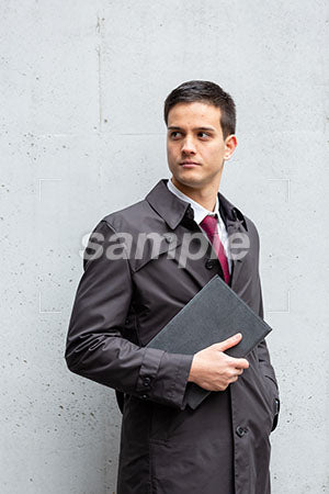 スーツでコートを着たビジネスマンの男性の普通の表情 左を見る a0010442PH