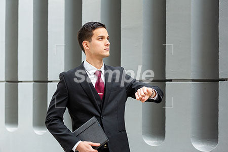 時間を気にするスーツのビジネスマン、普通の表情 右を見る a0010495PH