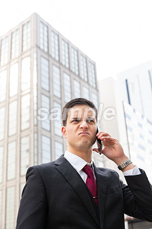 スマホで電話しながら怒るビジネスマンの男性 a0010562PH
