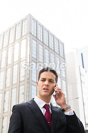 スマホで電話しながら嫌な話をしている男性 a0010574PH