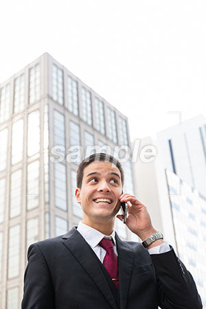 スマホで電話しながら右上を見て笑う男性 a0010587PH