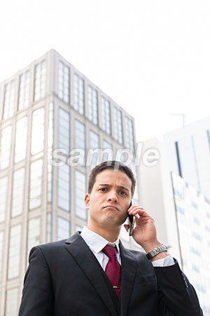 オフィス街でスマホで電話しながら考えるビジネスマン a0010589PH