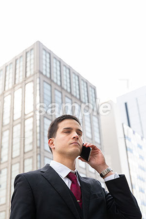 仕事で携帯電話をしながら目を閉じる男性 a0010594PH