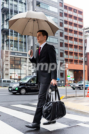 街中を傘をさして歩くビジネスマン a0010598PH