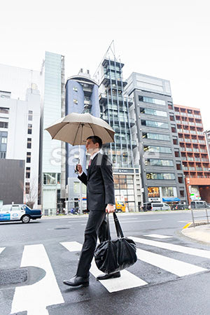 雨の日に傘をさして歩くビジネスマン a0010599PH