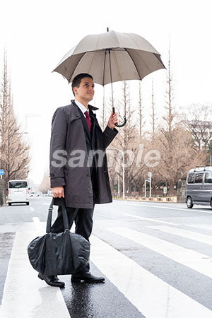 雨の中、傘をさして見上げる男性 a0010606PH