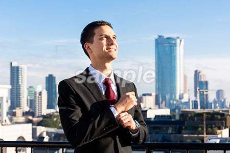 高いビル街と右上を見て微笑む男性 a0010742PH