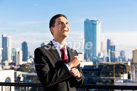 屋上で、右上を見て笑う男性 a0010747PH