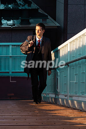 出勤のシーン 男性の普通の表情 歩道橋の階段を上る a0010864PH