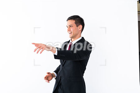 ジェスチャーする男性、左を指して笑う a0010911PH
