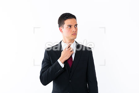 ネクタイを直すしぐさのビジネスマン、普通の表情 左を見る a0010996PH