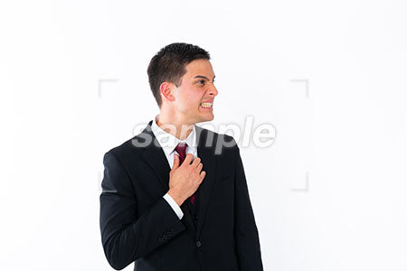 赤いネクタイを触りながら右を見て激怒の男性 a0011026PH