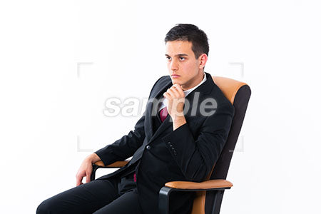 深く椅子に座っている男性が正面を見る a0011156PH