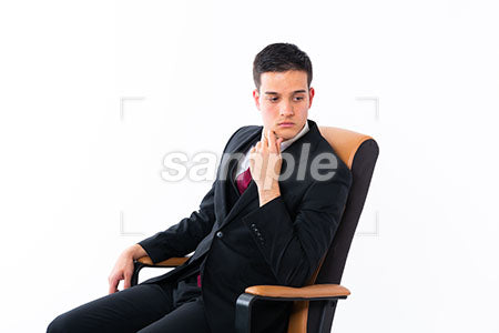 椅子に座って顎に手を添えて右下を見る若い男性 a0011159PH