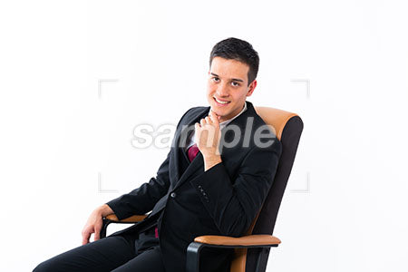 顔に手を添えて微笑む椅子に座った男性 a0011160PH