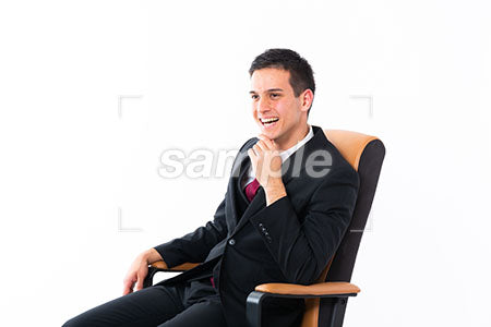椅子に座った男性の顎に手を添えて左を見て笑う a0011167PH