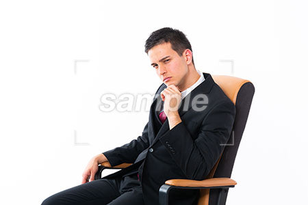 椅子の上で怒る表情の男性が左下を見る a0011169PH