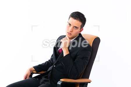 座りながら顎に手を添えて正面を見る男性 a0011182PH