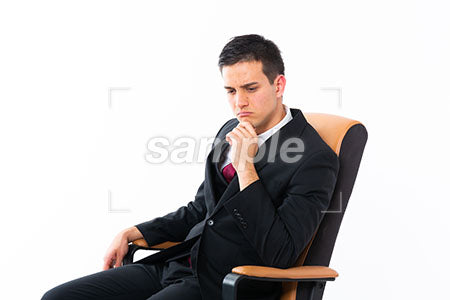 顎に手を添えて左下を見て悲しむ椅子に座った男性 a0011184PH