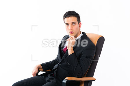 椅子に腰掛けてビジネスマンの男性の驚く表情 顎に手を添えて驚く a0011188PH