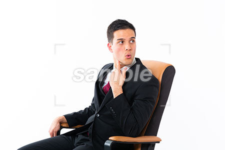 ビジネスマンの男性が椅子に座って左を見て驚く a0011193PH