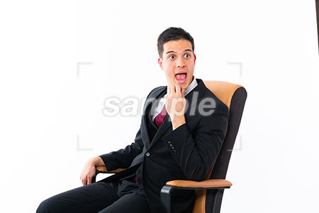 椅子に腰掛け顎に手を添えて右を見て驚く男性 a0011201PH