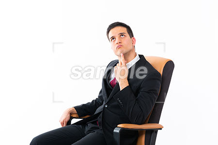椅子に腰掛けてビジネスマンの男性の悩む表情 a0011206PH