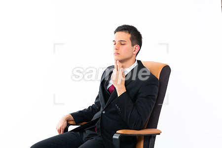 椅子に座った顎に手を添えて目を閉じる男性 a0011210PH