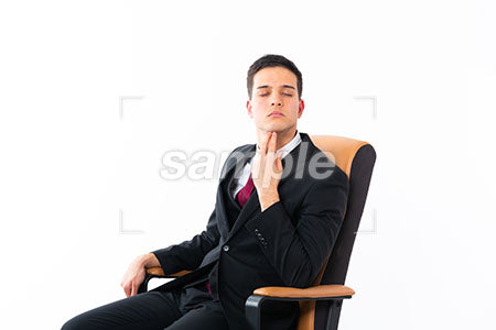 椅子に座って顎に手を添えて目を閉じる男性 a0011212PH