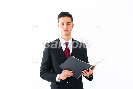 ビジネスマンの男性の瞑想の表情　ノートを持って目を閉じる a0011248PH