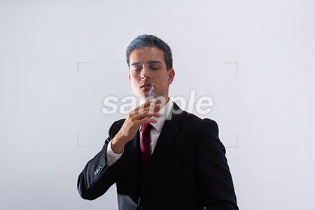 黒いスーツの男性が目を閉じてタバコを吸う a0011286PH