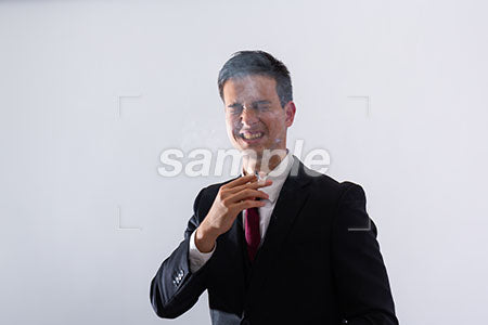タバコを吸って煙たい表情の男性 a0011287PH