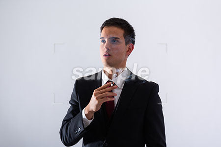 黒いスーツの男性が左を見て煙草を吸う a0011289PH