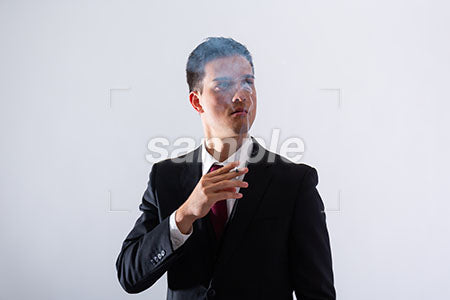 黒いスーツの男性が右上を見てタバコを吸う a0011290PH