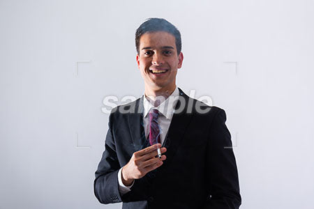 ビジネスマンの男性がタバコを持って笑う a0011292PH