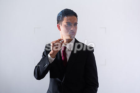 黒いスーツの男性がタバコを持って右を見て悲しむ a0011301PH